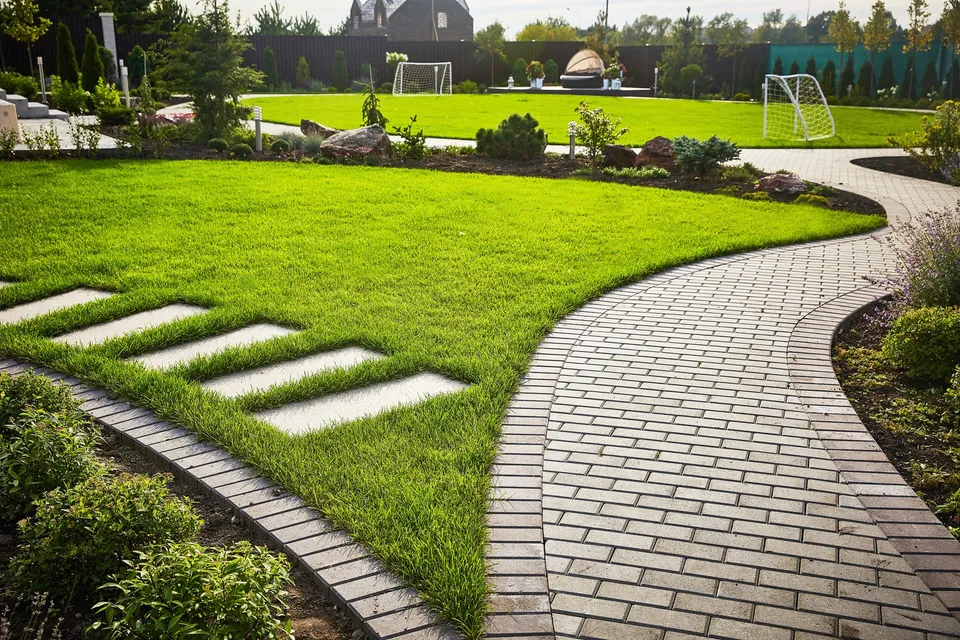 Manicured lawn and paver pathway maintained by Maintenance Masters