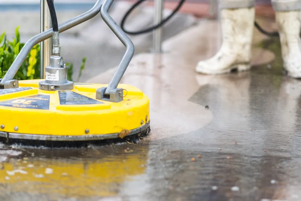 Rotary surface cleaner washing a concrete pad