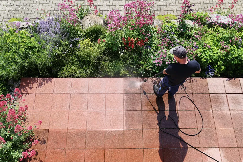 Freshly washed patio beside flowering garden beds