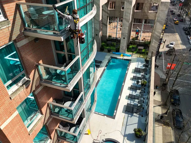 Aerial view of a rope-access window washing crew on a residential tower