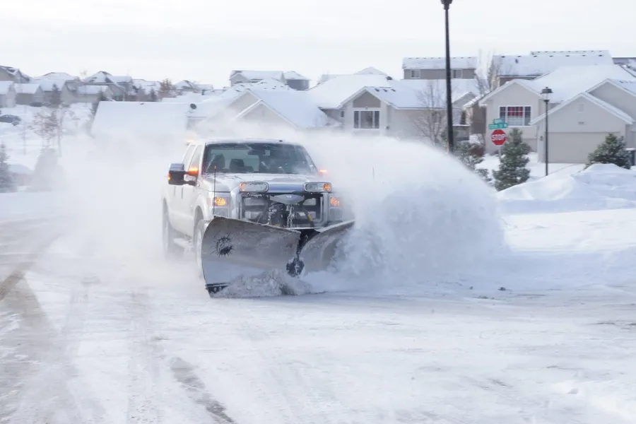 North Shore Snow plow truck clearing a snowy street